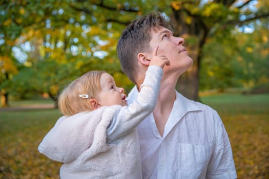 Dad and daughter enjoying autumn in a castle park at beautiful weather