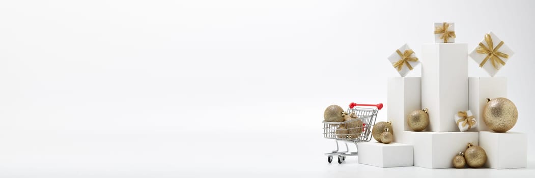 Shopping trolley, gift boxes and Christmas decorations isolated on white background with copy space. Christmas and New Year shopping. Winter sale. For design of advertising, web design