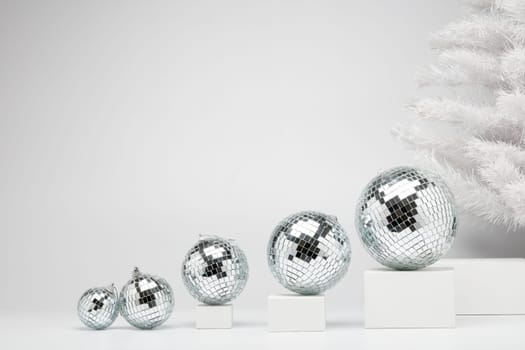 Festive composition with white geometrical figures, Christmas fir tree and mirorr balls isolated on white background with copy space. For design of advertising, web design. Christmas and New Year