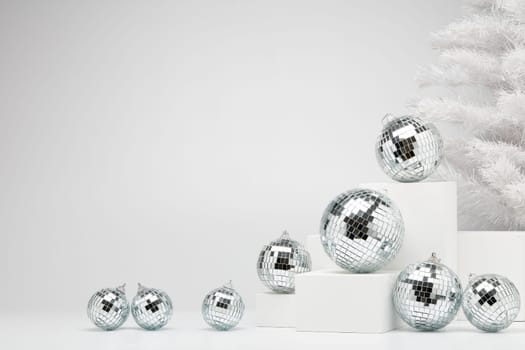 Festive composition with white geometrical figures, Christmas fir tree and mirorr balls isolated on white background with copy space. For design of advertising, web design. Christmas and New Year