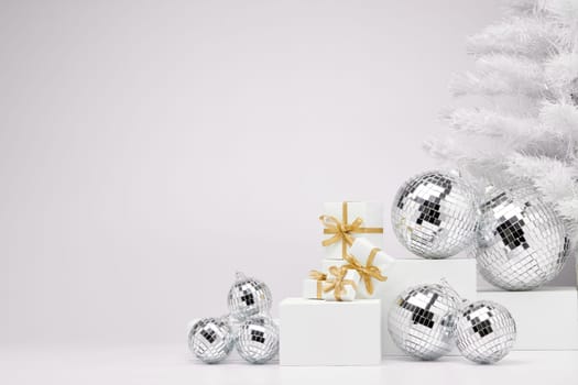 Festive composition with white geometrical figures, Christmas fir tree and mirorr balls isolated on white background with copy space. For design of advertising, web design. Christmas and New Year