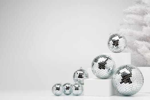 Festive composition with white geometrical figures, Christmas fir tree and mirorr balls isolated on white background with copy space. For design of advertising, web design. Christmas and New Year