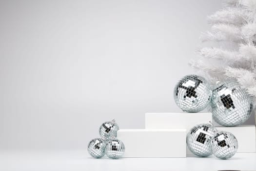 Festive composition with white geometrical figures, Christmas fir tree and mirorr balls isolated on white background with copy space. For design of advertising, web design. Christmas and New Year