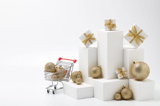 Shopping trolley, gift boxes and Christmas decorations isolated on white background with copy space. Christmas and New Year shopping. Winter sale. For design of advertising, web design