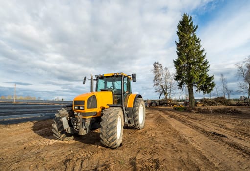 Yellow tractor stay at the field after works