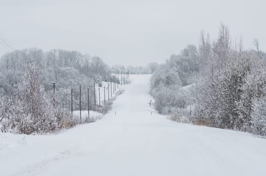 Road covered winter snow in the field