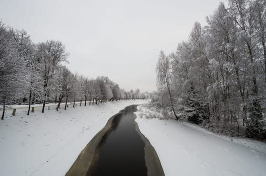 Small river with white snow covered trees
