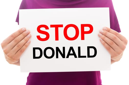 Girl holding white paper sheet with text STOP DONALD