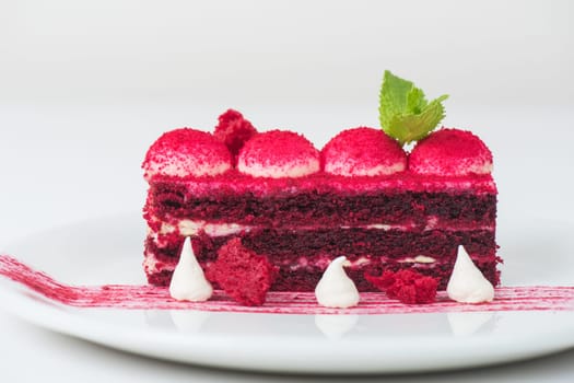 Plate with piece of delicious red velvet cake on white background