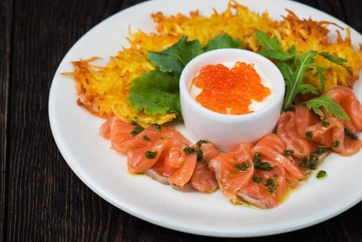 Plate with potato pancakes salmon fish and red caviar