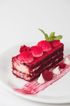 Plate with piece of delicious red velvet cake on white background