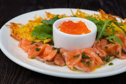 Plate with potato pancakes salmon fish and red caviar