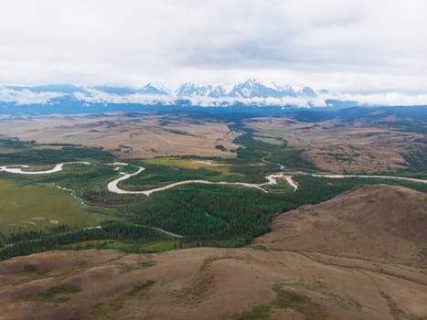 Aerial view of Kurai steppe and Chuya river on North-Chui ridge background. Altai mountains, Russia.
