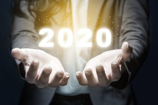 Businesswoman showing a digital number of 2020 on her hands. Happy New Year 2020