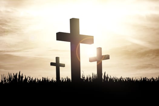 Christian cross on the grass with sunlight background