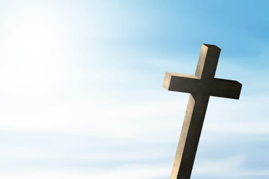 Christian cross with sunlight and blue sky background