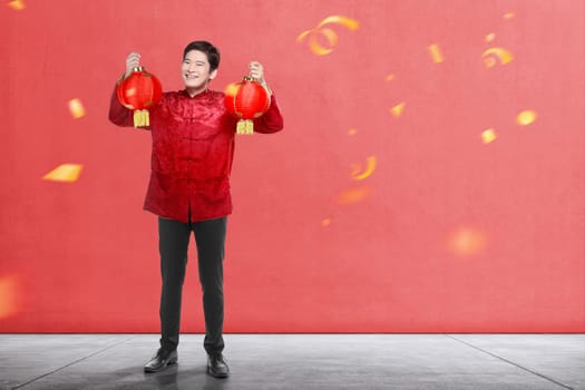 An Asian Chinese man in a cheongsam dress holding Chinese lantern. Happy Chinese New Year
