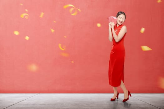 Asian Chinese woman in a cheongsam dress holding red envelopes. Happy Chinese New Year