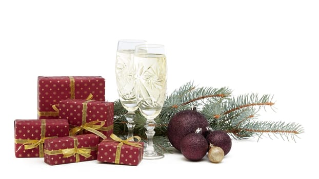 Still life with two champagne flutes, gift boxes and Christmas decoration with fir tree branch isolated on white background with copy space. Christmas and New Year shopping. Greeting card