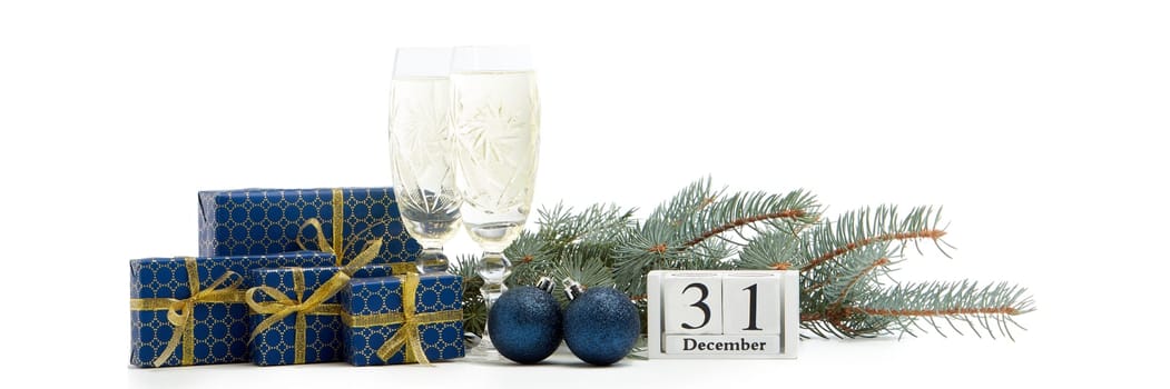 Still life with two champagne flutes, gift boxes and decoration with fir tree branch isolated on white background with copy space. New Year shopping. Greeting card