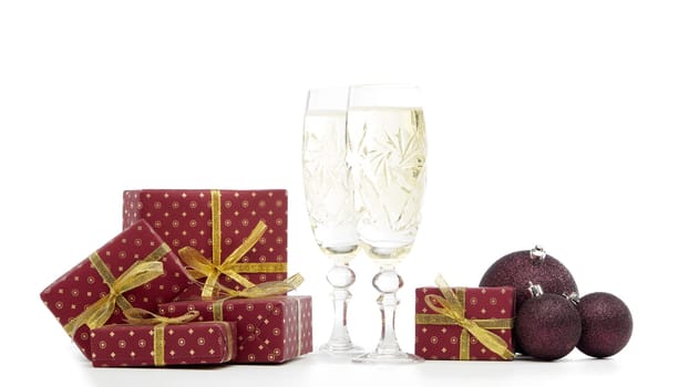 Still life with two champagne flutes, gift boxes and Christmas decoration isolated on white background with copy space. Christmas and New Year shopping. Greeting card