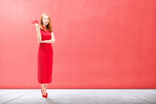 Asian Chinese woman in a cheongsam dress holding red envelopes. Happy Chinese New Year