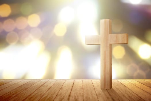 Christian cross on the wooden floor with blurred lights background