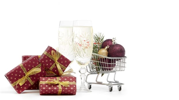 Shopping trolley, champagne flutes, gift boxes and Christmas decoration isolated on white background, Christmas and New Year shopping. Winter sale.