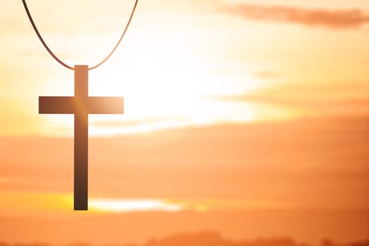Image of Christian cross with a sunset sky background