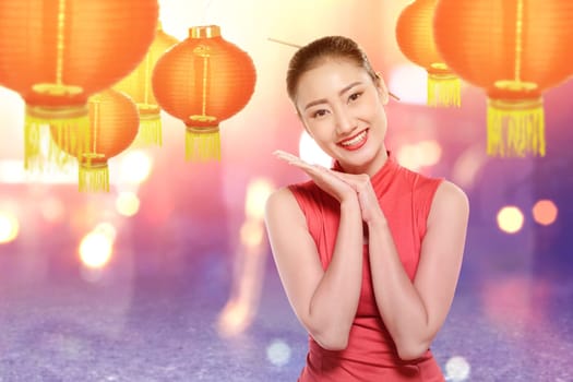 Asian Chinese woman in a cheongsam dress celebrates Chinese New Year. Happy Chinese New Year