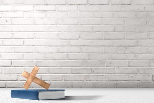 Christian Cross and bible on the table with brick wall background