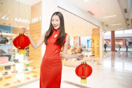 Asian Chinese woman in a cheongsam dress holding Chinese lantern. Happy Chinese New Year