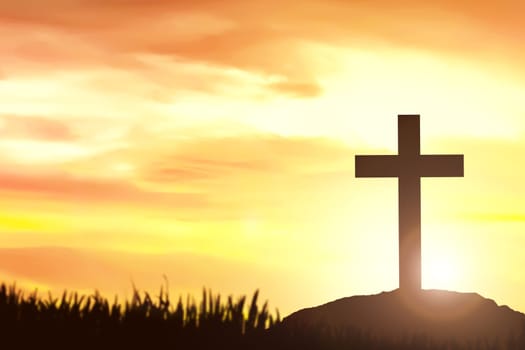 Christian Cross on the field with a sunset sky background