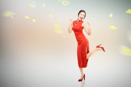 Asian Chinese woman in a cheongsam dress celebrates Chinese New Year. Happy Chinese New Year