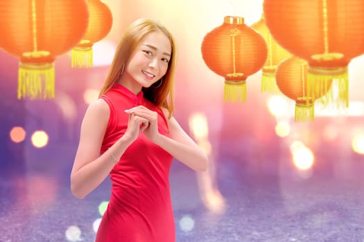 Asian Chinese woman in a cheongsam dress with congratulations gesture. Happy Chinese New Year