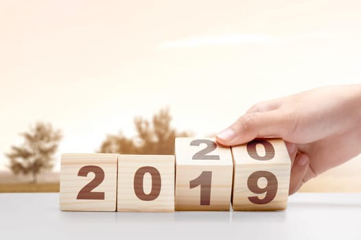 Hand changes the wooden cube from 2019 to 2020. Happy New Year 2020