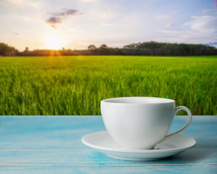 A cup of coffee with rice field rural with colorful of sky in morning light, Relaxation concept