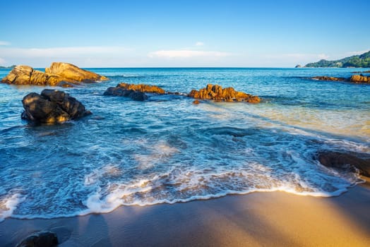 Beach with sand and blue sea and blue sky in holiday summer season