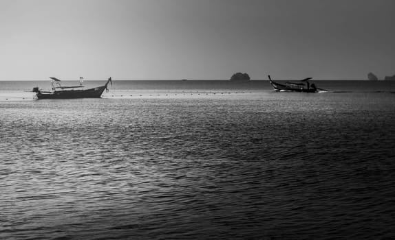 Sea sunrise or sunset with fishing boat and sunlight in morning light, Black and white and monochrome style