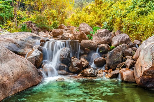 River stone and waterfall with tree colorful, View water river in countryside, Stone river in multi color tree leaf in forest