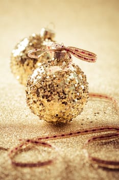 Golden christmas balls on glitter background with copy space. Glitter background.