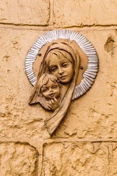 Virgin Mary icon. Religious icon on stone wall of Virgin Mary and the holy child Jesus