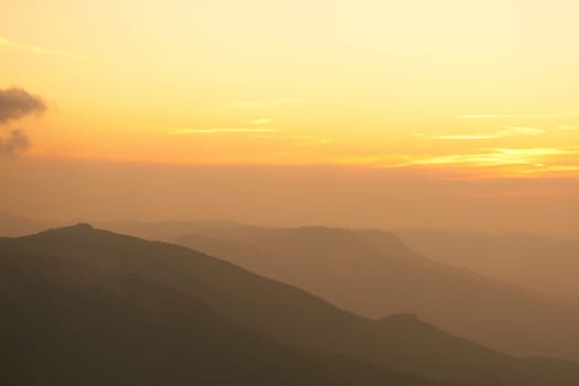Beautiful sunset at the mountains. Colorful landscape with sun and orange sky