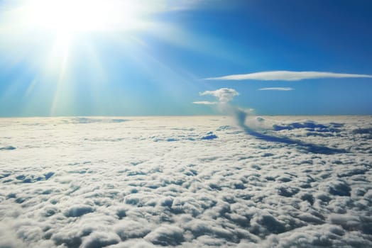 Blue sky, sun and clouds. Plane view above the earth, can be used for background