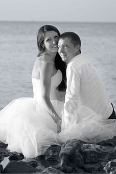 Beautiful wedding couple - bride and groom hugging at the beach. Just married. Black and white, sepia