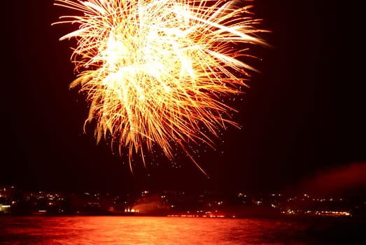 Red colorful holiday fireworks on the black sky background.