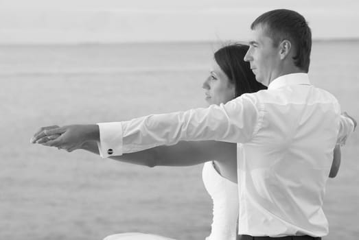 Beautiful wedding couple - bride and groom hugging at the beach. Just married. Black and white, sepia