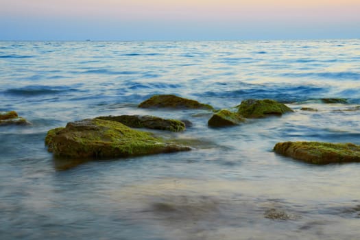 Rocks in the sea against beautiful sunset