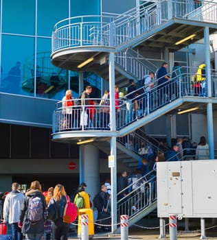 LARNACA, CYPRUS - FEBRUARY 12, 2019: People climbing up stairs with luggage to Larnaca airport terminal building, Cyprus