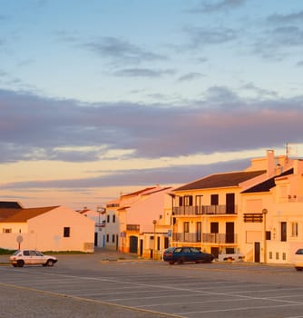 Sunset view of traditional Portugal town architecture and cars on a parking. Baleal, Portugal